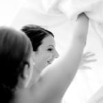 A bride gets into her dress before her wedding.