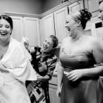 All the girls laugh as the bride puts on her dress captured by Portland photographer, Daniel Stark.