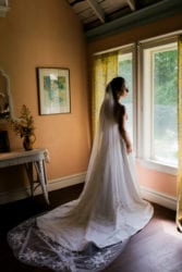 Bride looking out the window on her wedding day