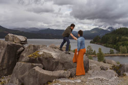 bride and groom stepping onto rocks in Oregon
