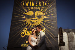 a bride and groom in front of a winery sign