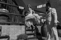 brides dress blows in the wind as she climbs stairs at The Sunshine Mill