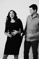 expecting parents laugh during a maternity session in studio