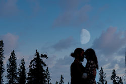 The moon rises over a silhouette of a couple during their Bend engagement photos