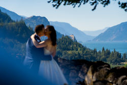 Newlyweds kiss with Columbia Gorge in background.