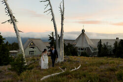wedding couple walking with timberline lodge in the background