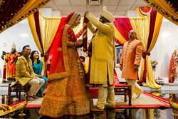 bride and groom exchanging a garland for Indian wedding tradition