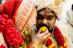 bride feeding the groom sweets during wedding ceremony at Portland hindu temple