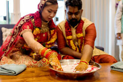 bride and groom with hands in milk for post Indian wedding tradition