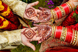 bride and groom showing their henna detail on hands