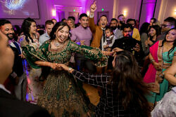 bride swinging her arms while dancing at indoor wedding reception