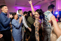 woman with tattoos dancing and smiling at a wedding reception in Portland Oregon
